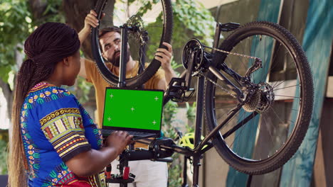 couple repairs bike with isolated laptop