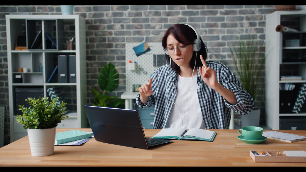 Mujer trabajando y disfrutando de la música en su escritorio
