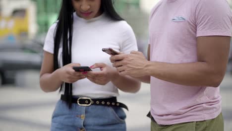 fotografía recortada de jóvenes que usan teléfonos inteligentes en la calle