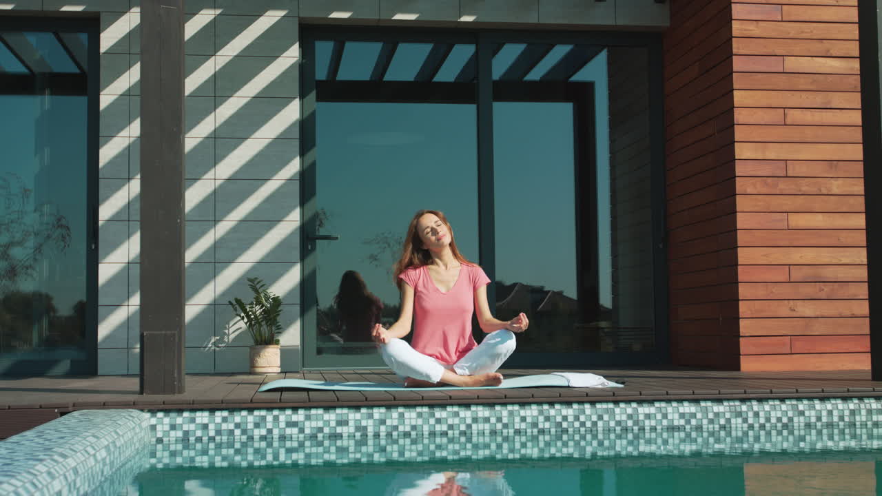 donna d'affari che medita vicino alla piscina. donna rilassata che fa esercizio di yoga.