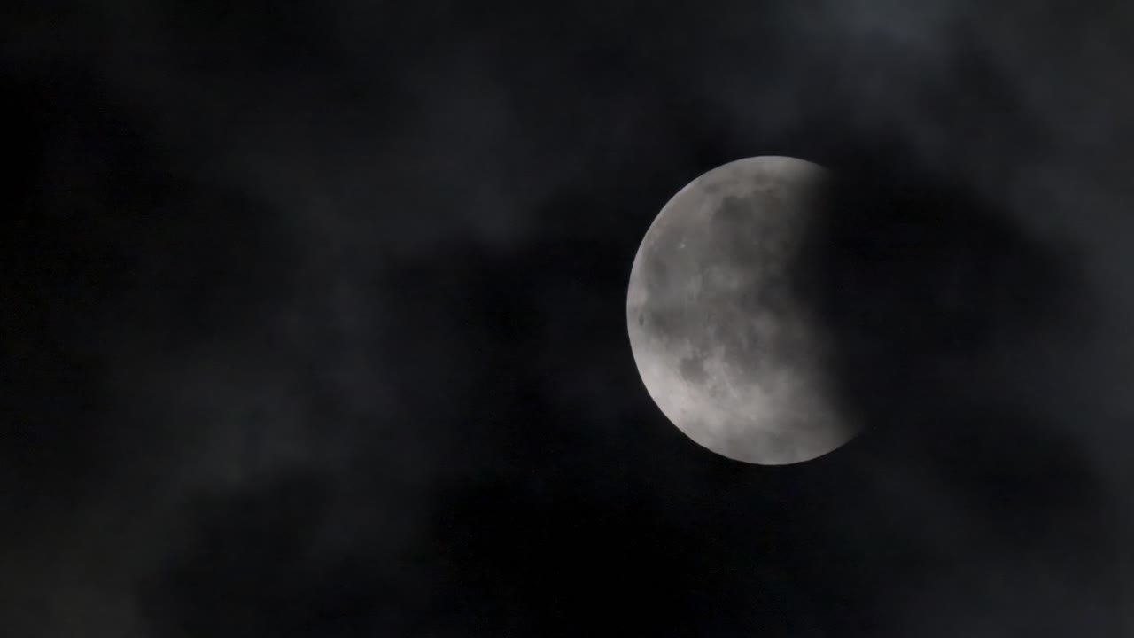 Lunar eclipse. The moon on the background of a dark sky with clouds