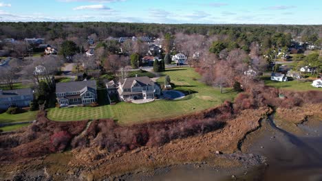 luxury colonial house on coastal marsh with a groomed lawn and inground pool