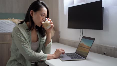 Asian-writer-with-laptop-and-coffee-at-home