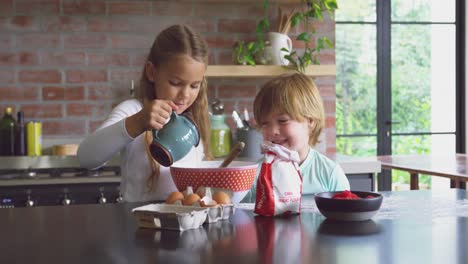 Siblings-preparing-cookie-on-worktop-in-kitchen-at-comfortable-home-4k