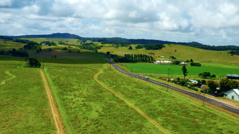 green fields and country road in atherton tablelands, queensland, australia - aerial drone shot