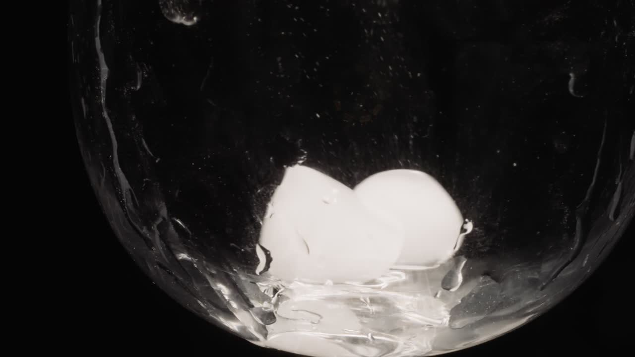 cubitos de hielo cayendo en vidrio vacío deslizándose por los lados