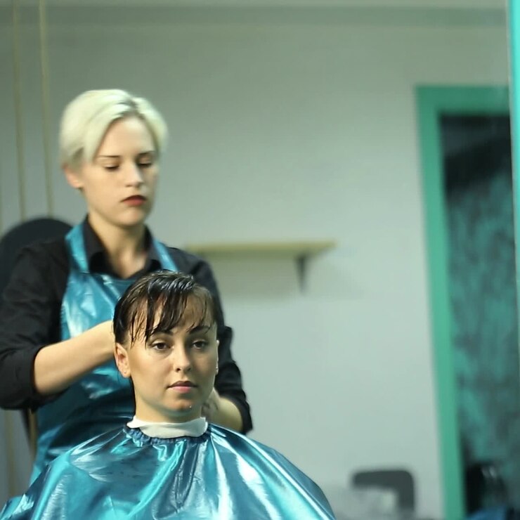 Parrucchiera che tinge i capelli di una cliente