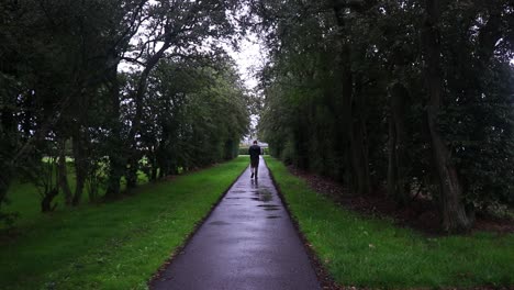 guy walking down an wet asphalt road.