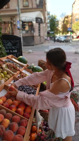 young woman shopping for fruit at an outdoor market