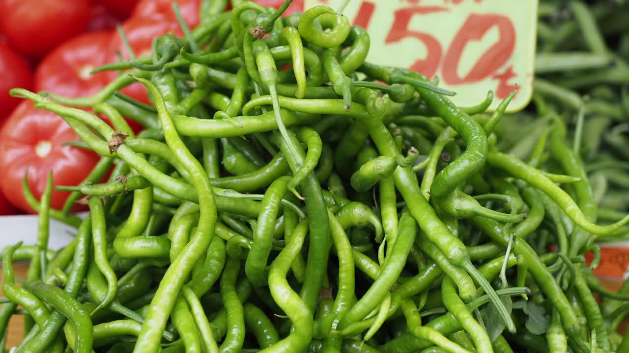 una pila de pimientos verdes frescos en un mercado