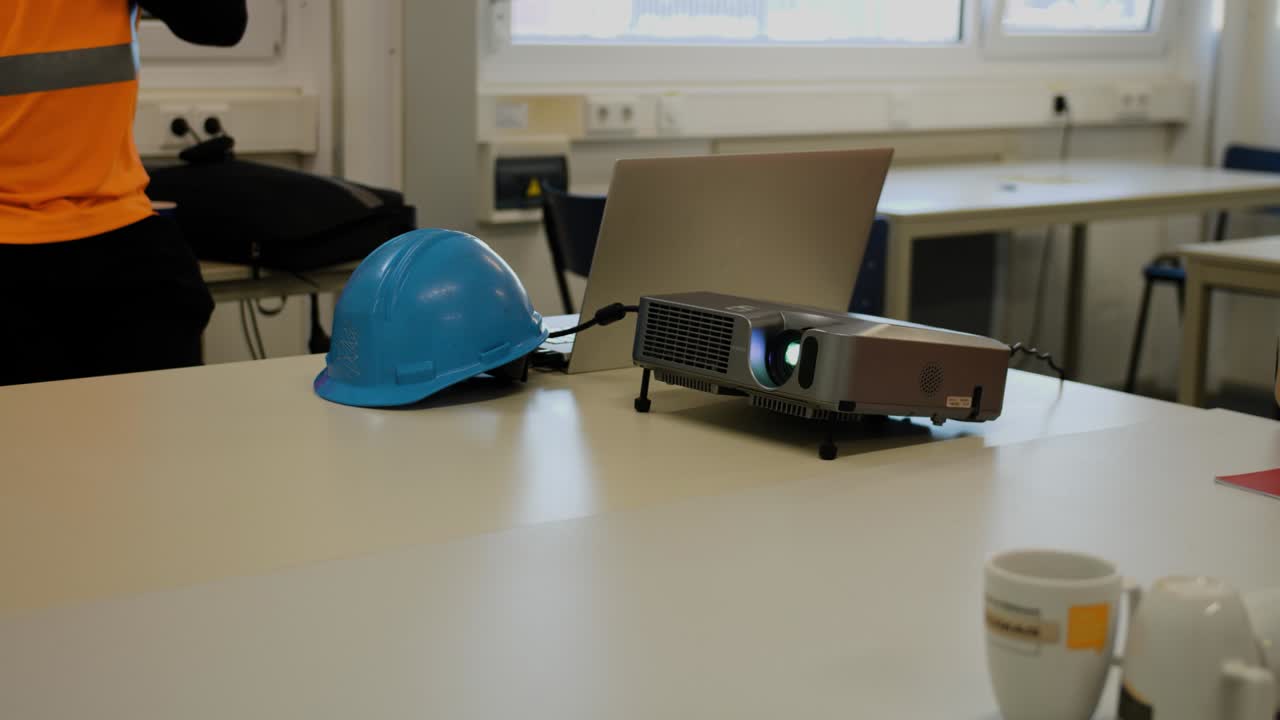 casco de construcción y proyector en la mesa