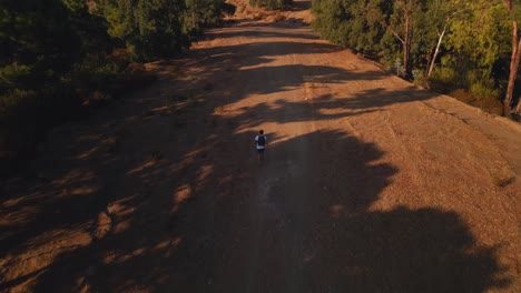 aerial view of backpacker running on a dirt trail