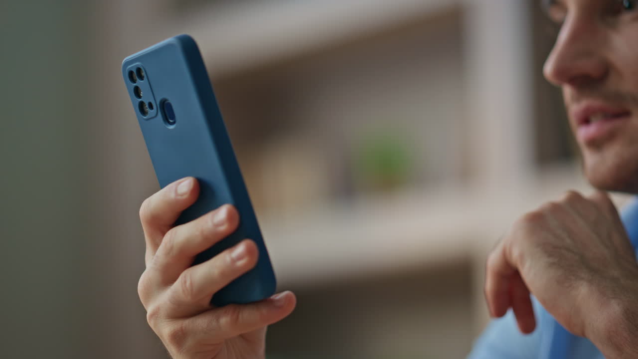 Smiling boss reading sms on smartphone at office close up. Happy businessman