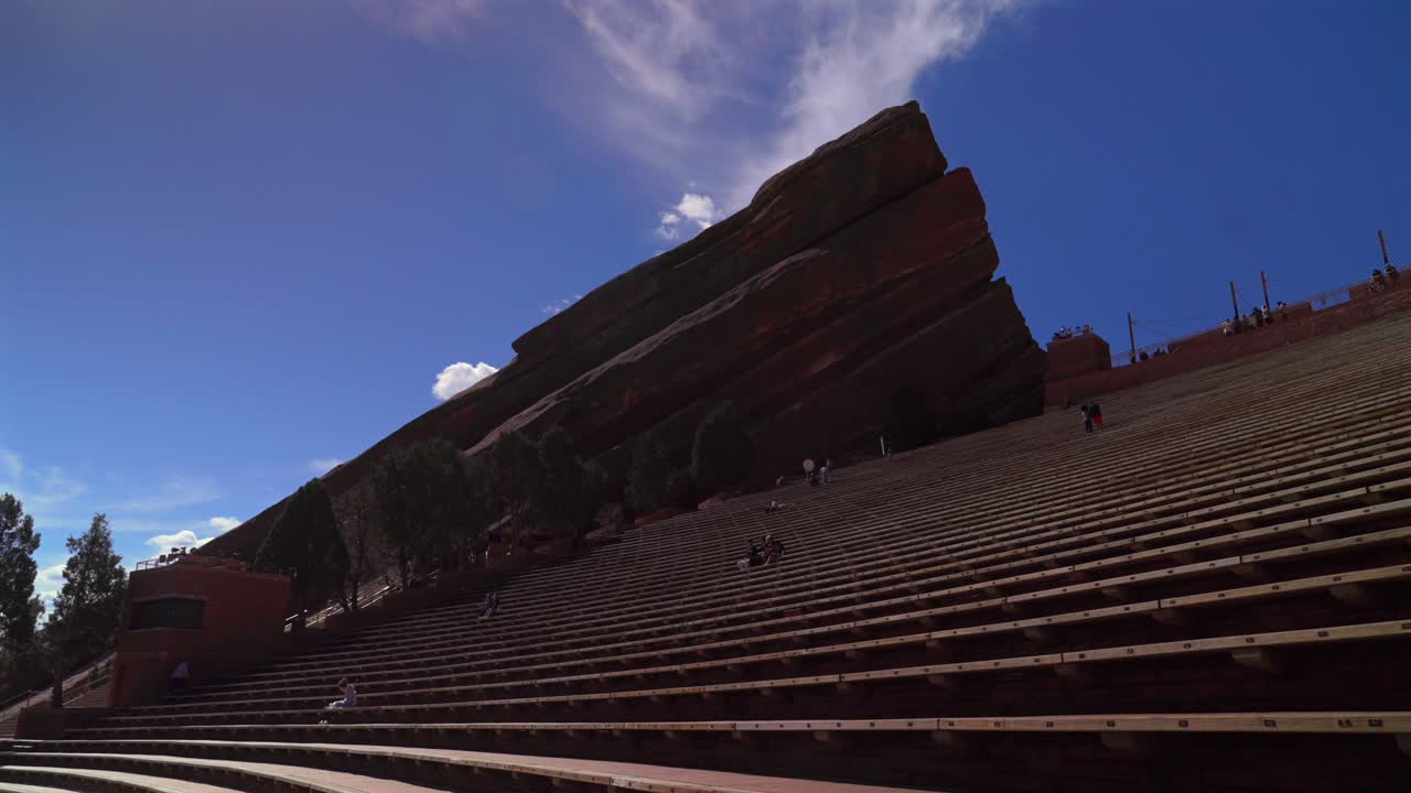 Red Rocks Park and Amphitheater band music staircase stage Morrison Colorado aerial drone mid winter sunny blue sky clouds tourist destination large sandstone feature forward pan up motion