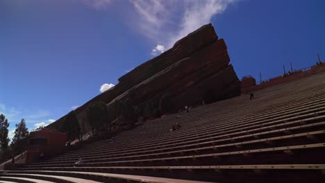 red rocks park and amphitheater band music staircase stage morrison colorado aerial drone mid winter sunny blue sky clouds tourist destination large sandstone feature forward pan up motion