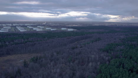 Vista-Aérea-Del-Paisaje-Forestal-Y-Almacenamiento-De-Base-De-Combustible-En-Gdansk-Durante-El-Día-Nublado