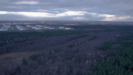 vista aérea del paisaje forestal y almacenamiento de base de combustible en gdansk durante el día nublado