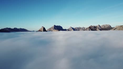 rocky peaks of massive mountains in fluffy clouds