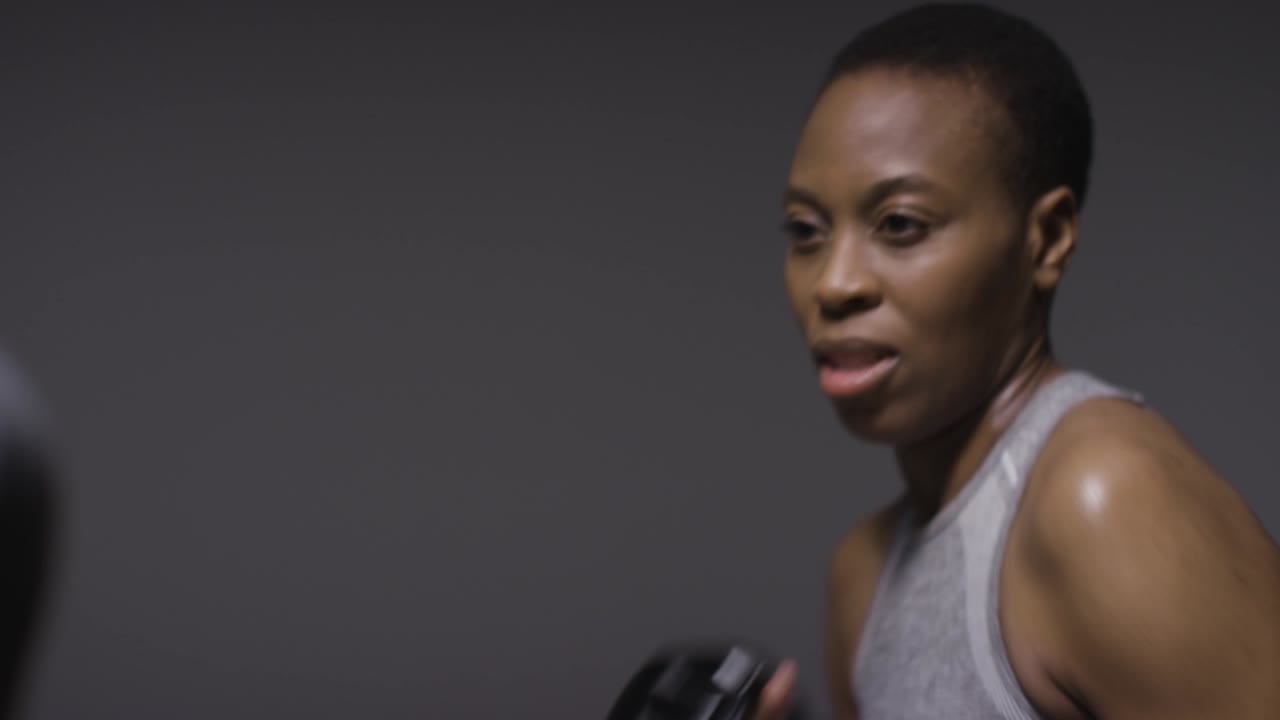 Studio Shot Of Woman Wearing Boxing Gloves Sparring With Trainer 3