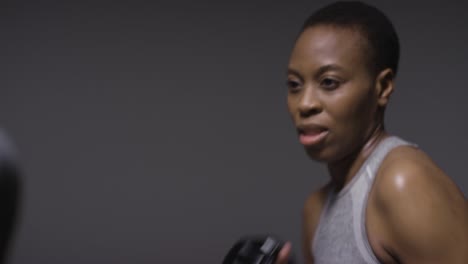 Studio-Shot-Of-Woman-Wearing-Boxing-Gloves-Sparring-With-Trainer-3