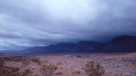 gimbal panning shot of the dramatic cliffs mired in thick desert clouds in red rock canyon, nevada at low light