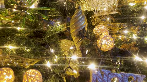 Schöne-Lichter-Funkeln-Auf-Grünem-Weihnachtsbaum,-Goldenes-Dekor,-Nahaufnahme