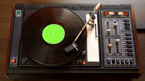 vinyl record pleer. plays song from an old turntable 4k top view.