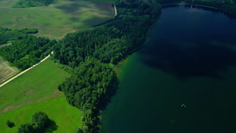 scenic aerial view of emerald lake with vegetated shore at sunset