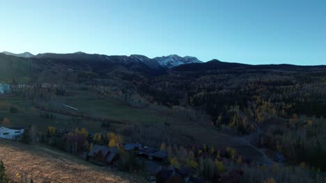 Aerial-drone-shot-pulling-back-over-a-tree-line-in-Mountain-Village,-CO