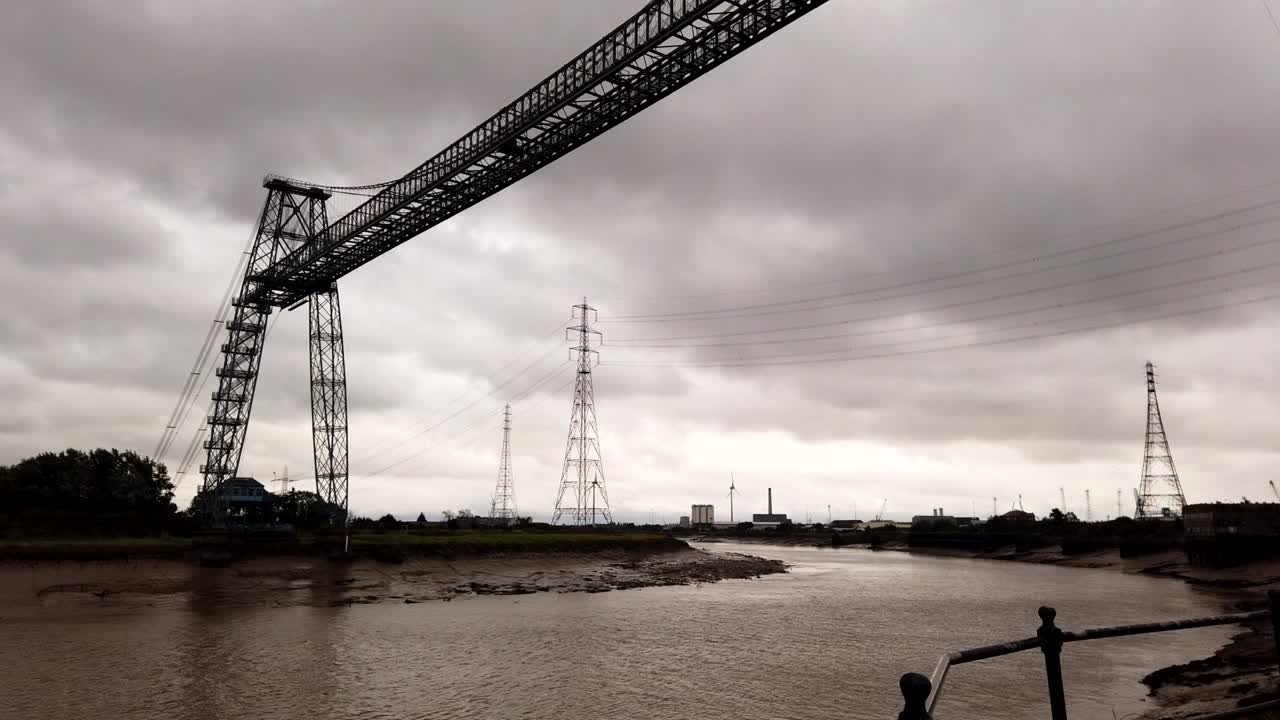 Time lapse shot of Newport Transporter Bridge working and crossing river usk during dark cloudscape at sky