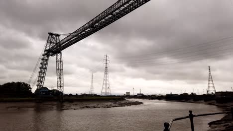 Toma-De-Lapso-De-Tiempo-Del-Puente-Transportador-De-Newport-Trabajando-Y-Cruzando-El-Río-Usk-Durante-El-Paisaje-Nublado-Oscuro-En-El-Cielo