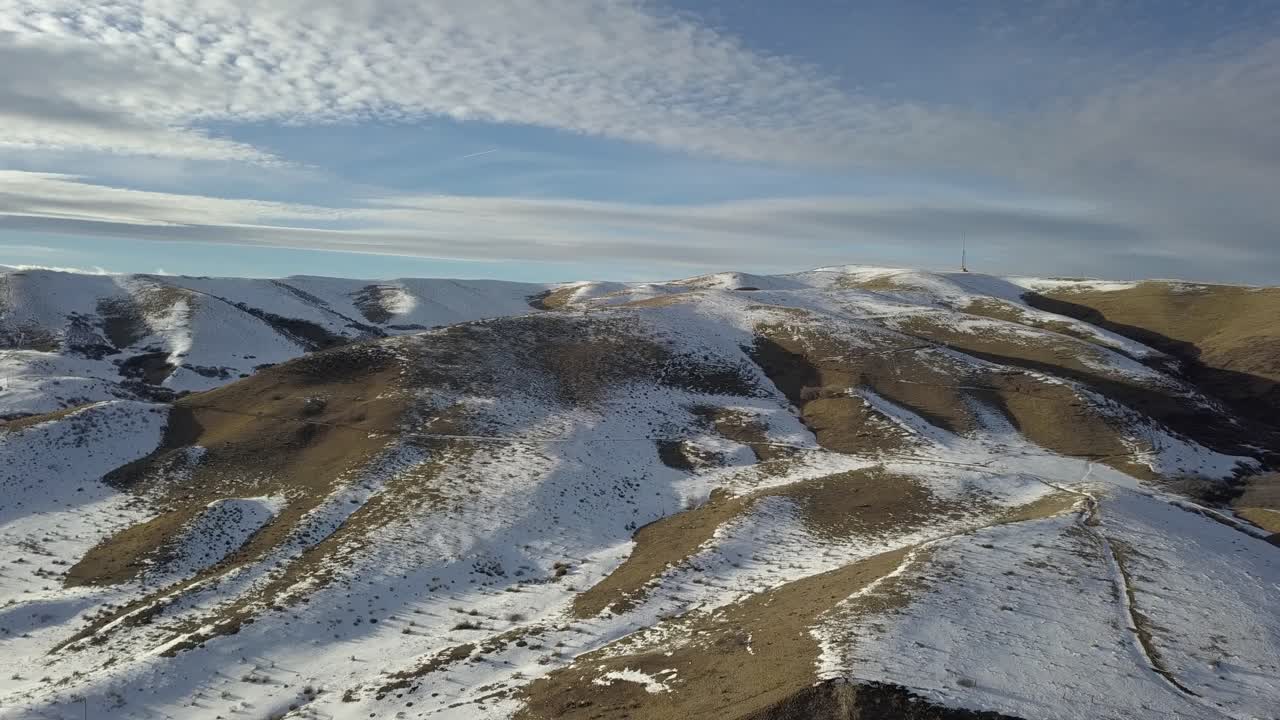 En luftpanoramaoptagelse over et sneklædt bjerg.