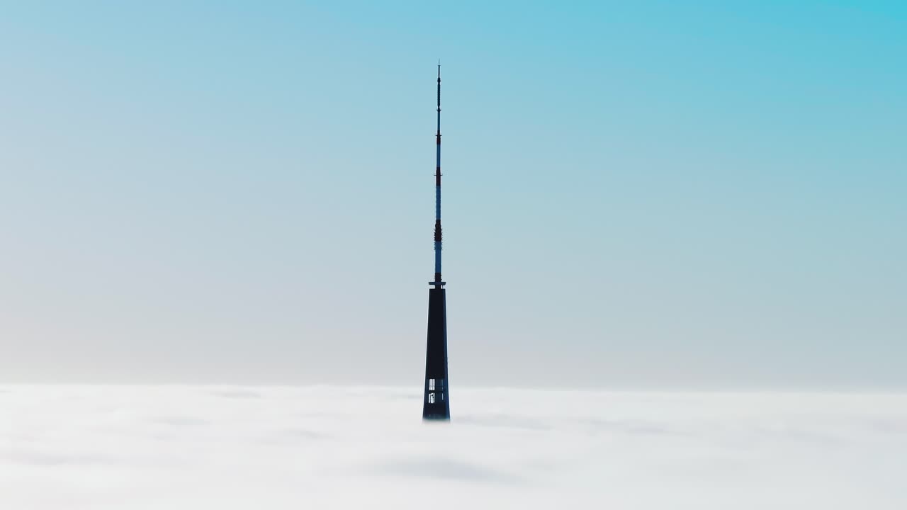 Warm golden sunrise penetrates dense clouds over Riga in dramatic drone shot