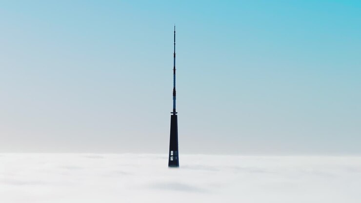 Warm golden sunrise penetrates dense clouds over Riga in dramatic drone shot