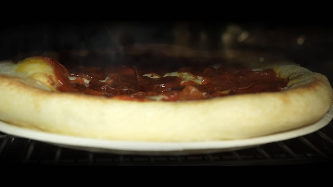 Pepperonipizza som bakes i ovnen - boblende, seig ost som smelter i tidsforløp.
