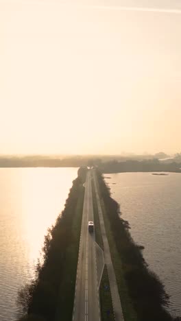 serene road through watery landscape at sunrise