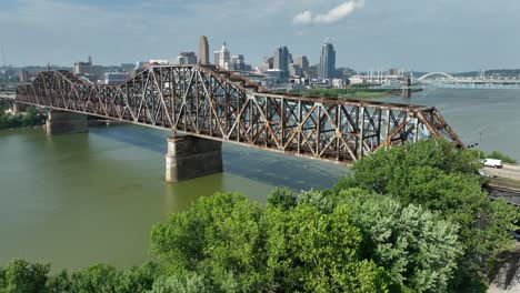 Aerial-reveal-of-old-bridges-on-Ohio-River-with-Cincinnati-skyline-in-distance