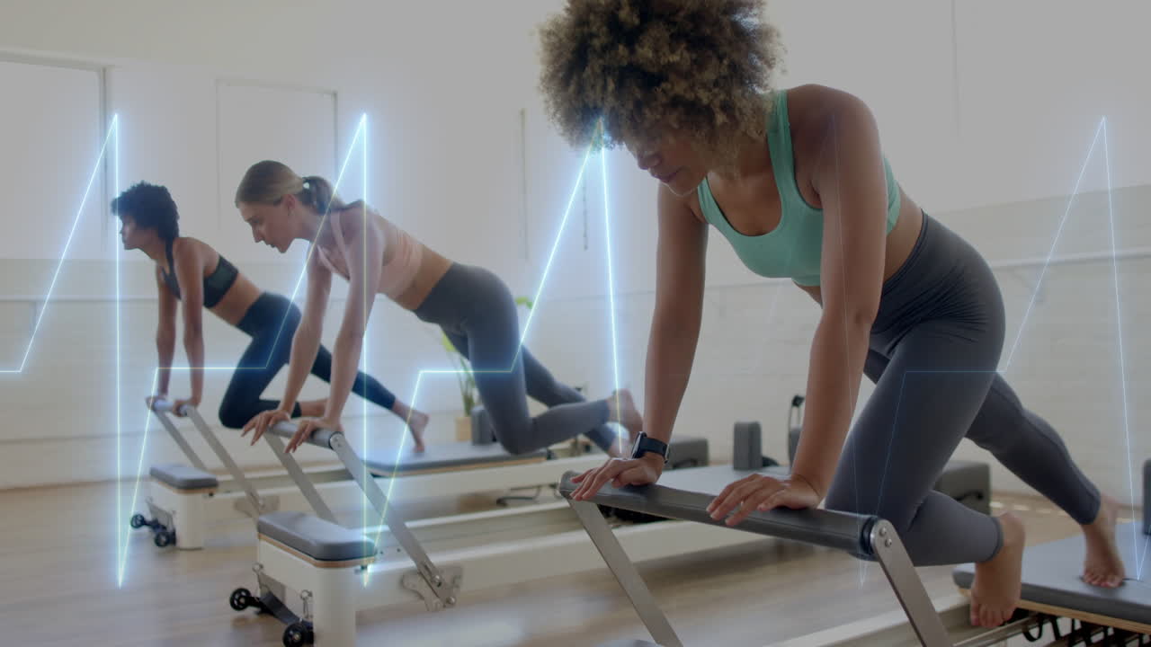 Exercising on reformer machines, women with heartbeat animation overlay in gym