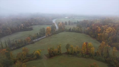 trees, fields, hills, fog, and a rural highway in the middle of autumn