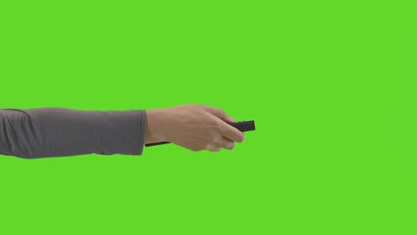 primer plano de estudio de una mujer sosteniendo y usando el control remoto de la televisión contra la pantalla verde