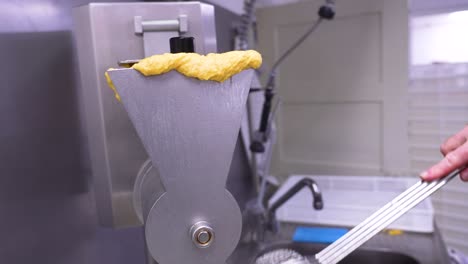 cooking noodle in a boiling hot pot straight from a pasta maker in a kitchen
