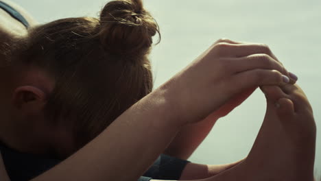 chica de primer plano haciendo ejercicios de yoga en la playa. mujer estirando la naturaleza de verano.