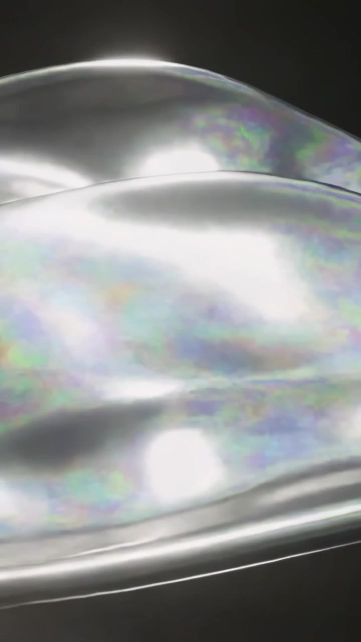 Vertical video: Sweeping ridge starting metal sheet flowing in dark studio, specular spots shifting