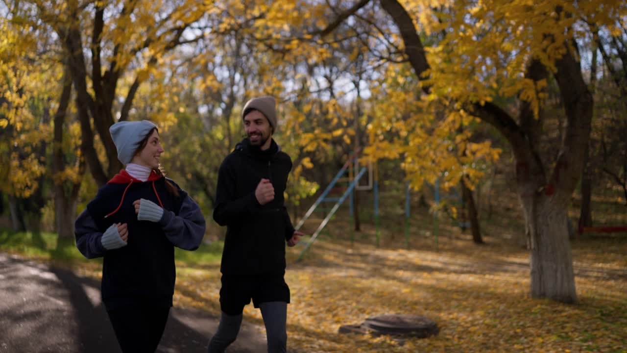 пара бежит в осеннем парке