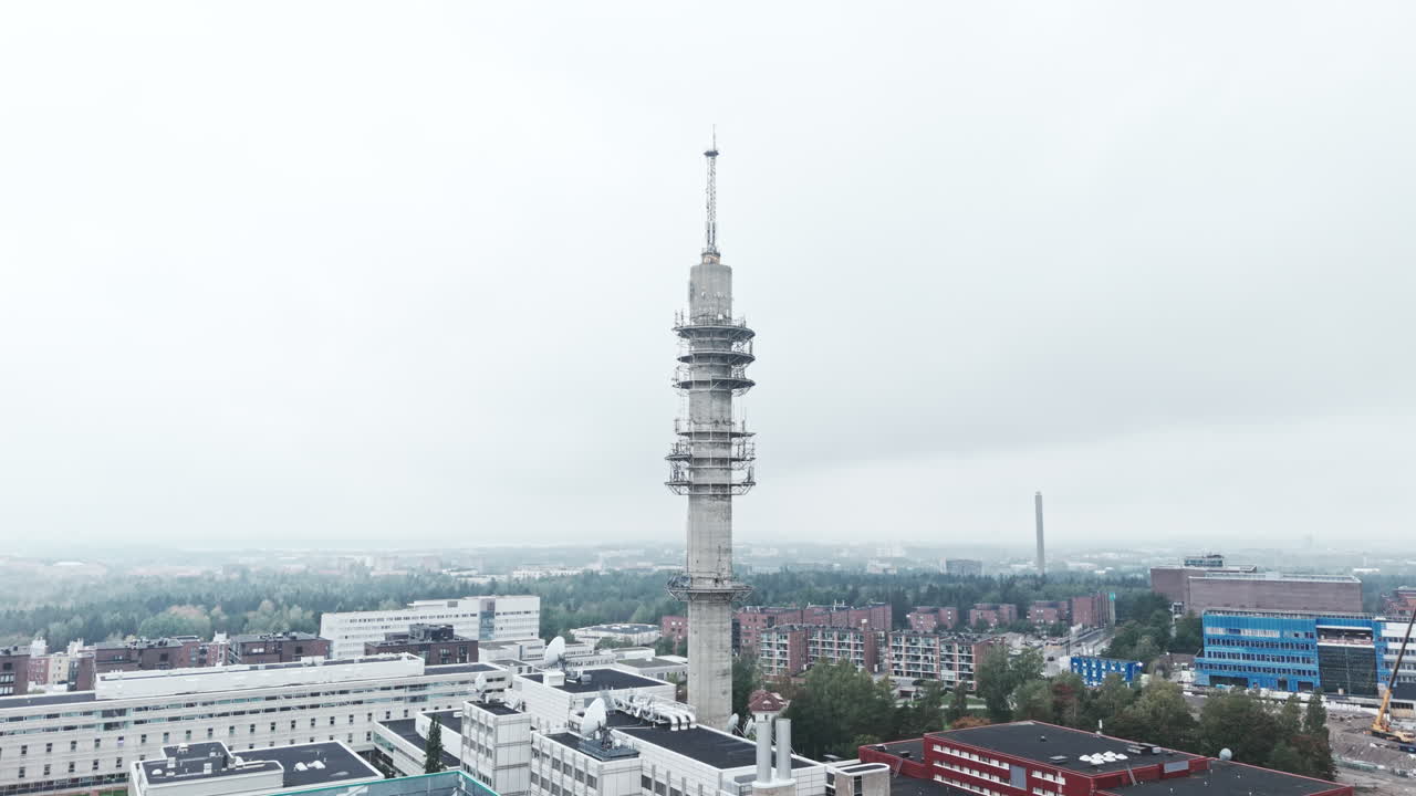 Aerial wide shot of a bleak industrial concrete television and radio link tower in Pasila, Helsinki, Finland on a bright and foggy day