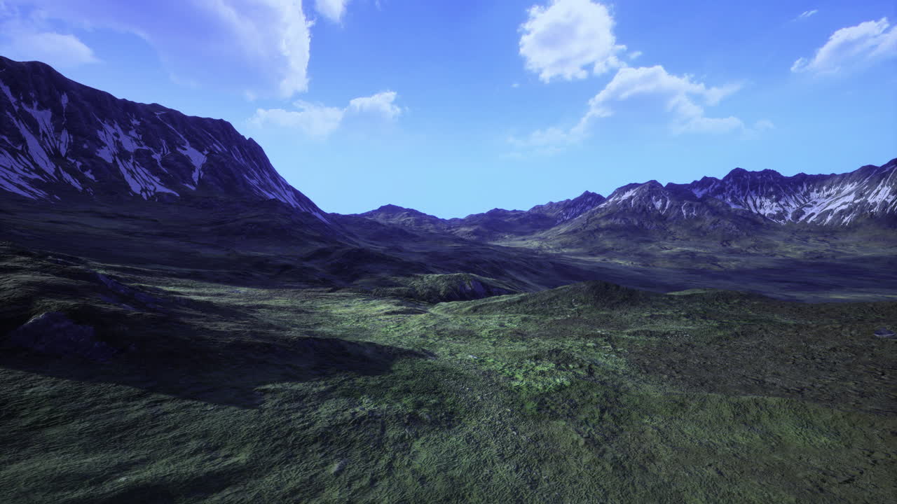 Snow capped mountains surround lush green valleys under a clear blue sky