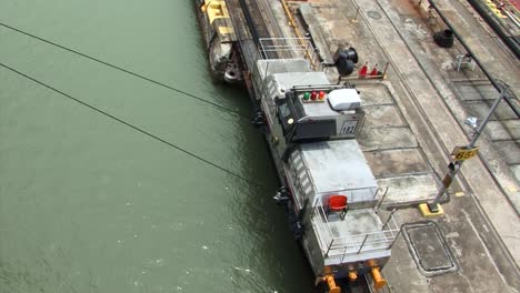 locomotive pulling the ship thru pedro miguel locks on starboard side