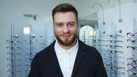man in optical shop choosing eyeglasses. stylish man looking for the best optical glasses