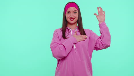 sincere responsible teen girl raising hand to take oath, promising to be honest and to tell truth