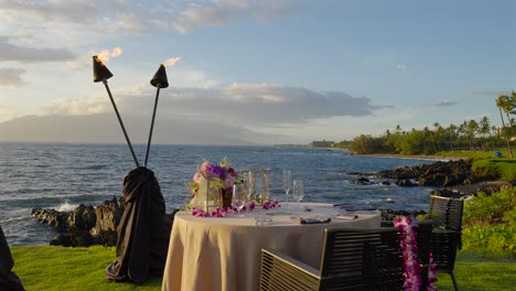 romantic table for two overlooking the sea and sunset, maui hawaii - pull back and slow motion